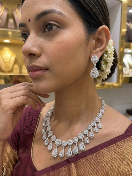 Woman wearing a diamond necklace and earrings in a jewelry store setting