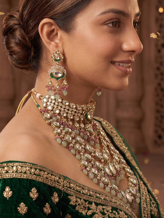 Woman wearing traditional jewelry with a green outfit against a warm-toned background