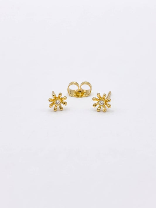 Gold flower-shaped earrings on a white background