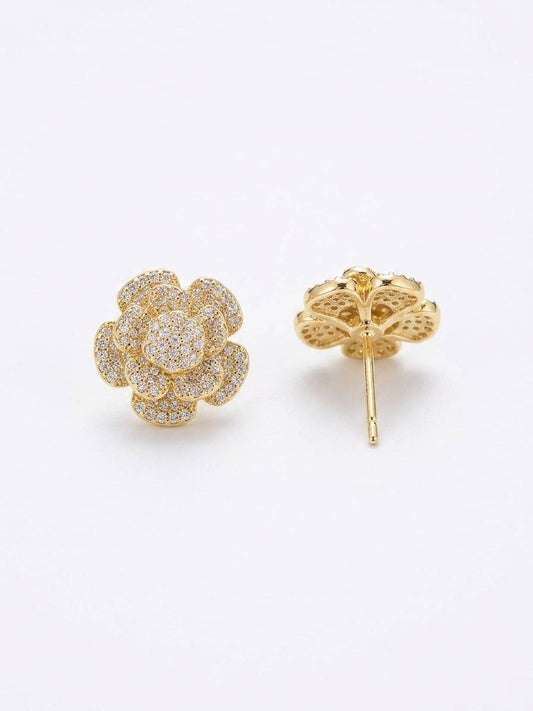 Gold floral earrings on a white background