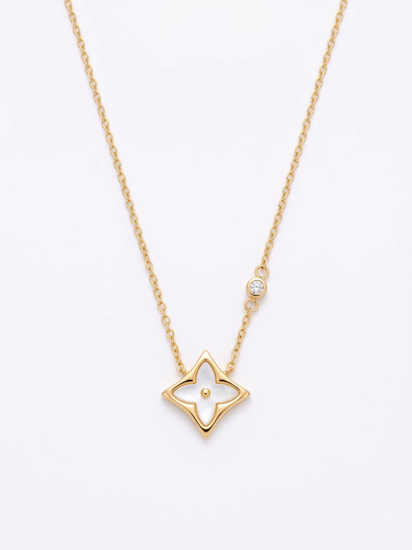 Gold star-shaped pendant necklace on a white background