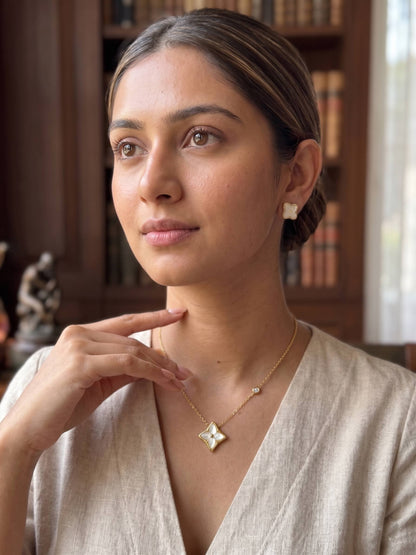 Woman wearing a necklace with a star-shaped pendant in a warm indoor setting.