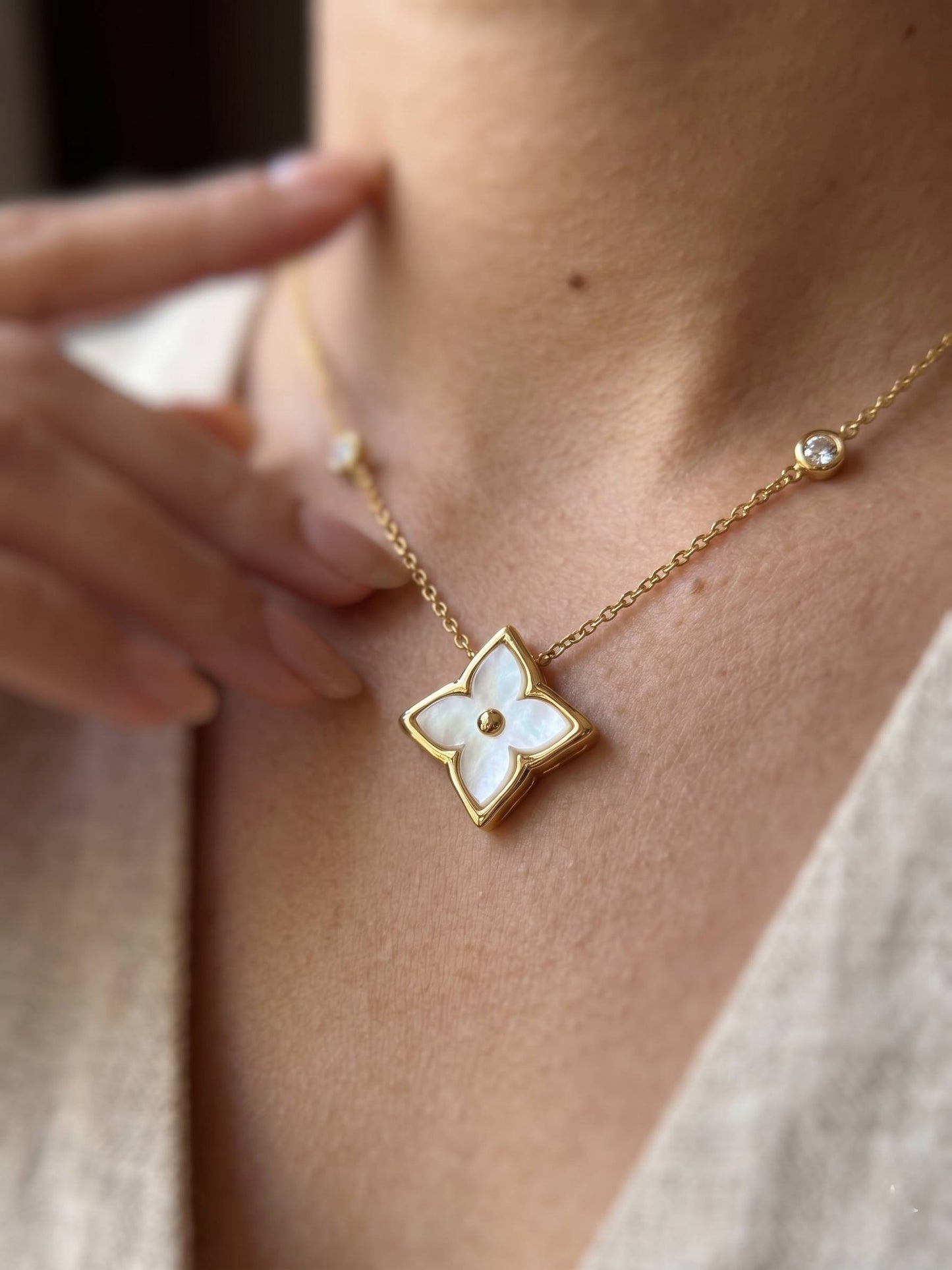 Necklace with a floral pendant worn by a person