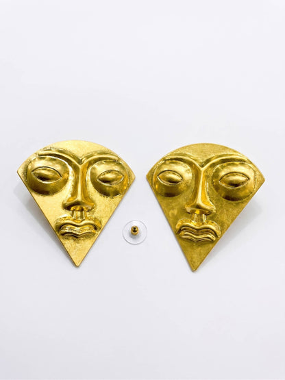 Gold triangular face earrings on a white background
