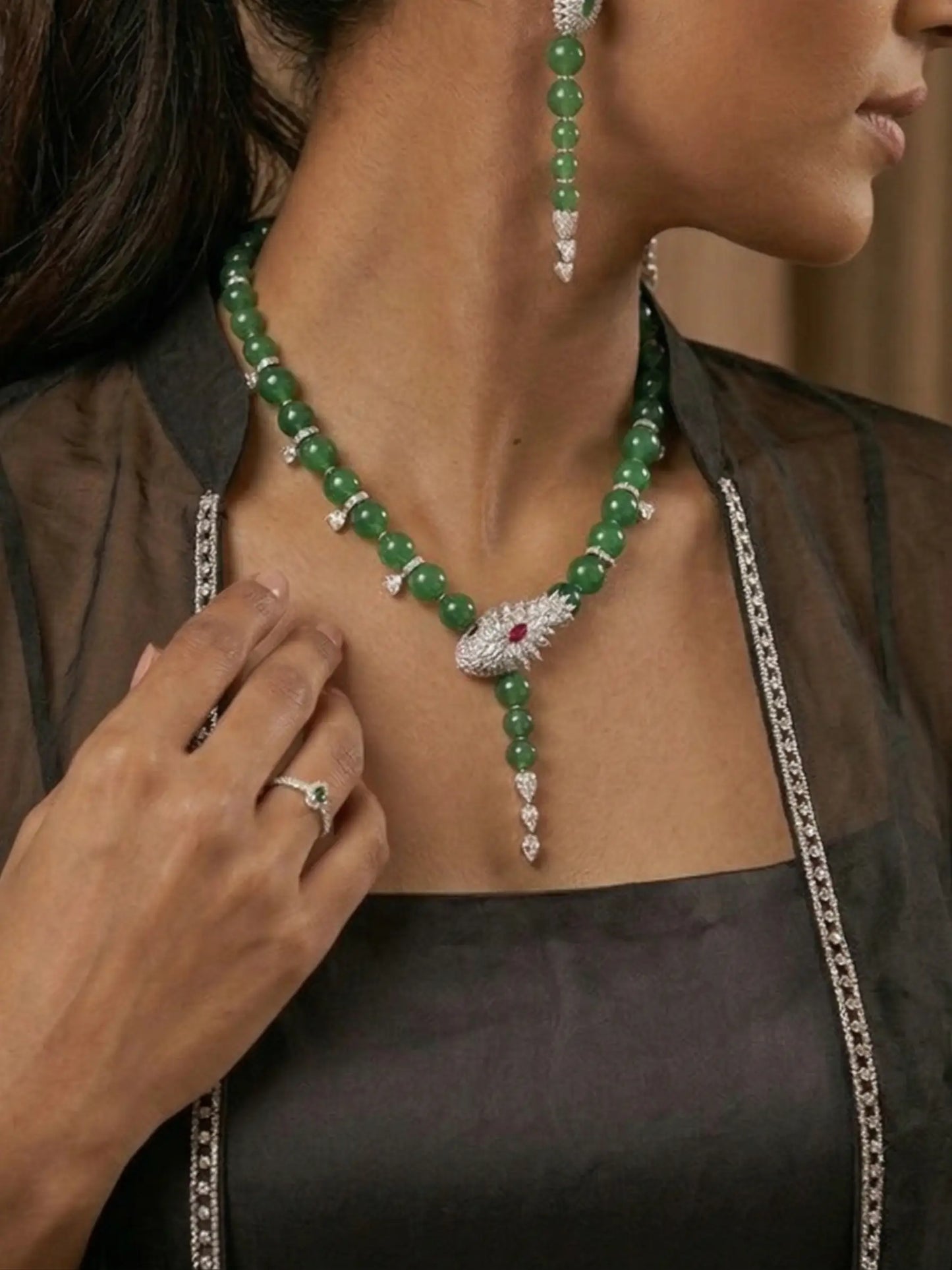 Close-up of a woman wearing a green beaded necklace with a silver chain, focusing on the jewelry.