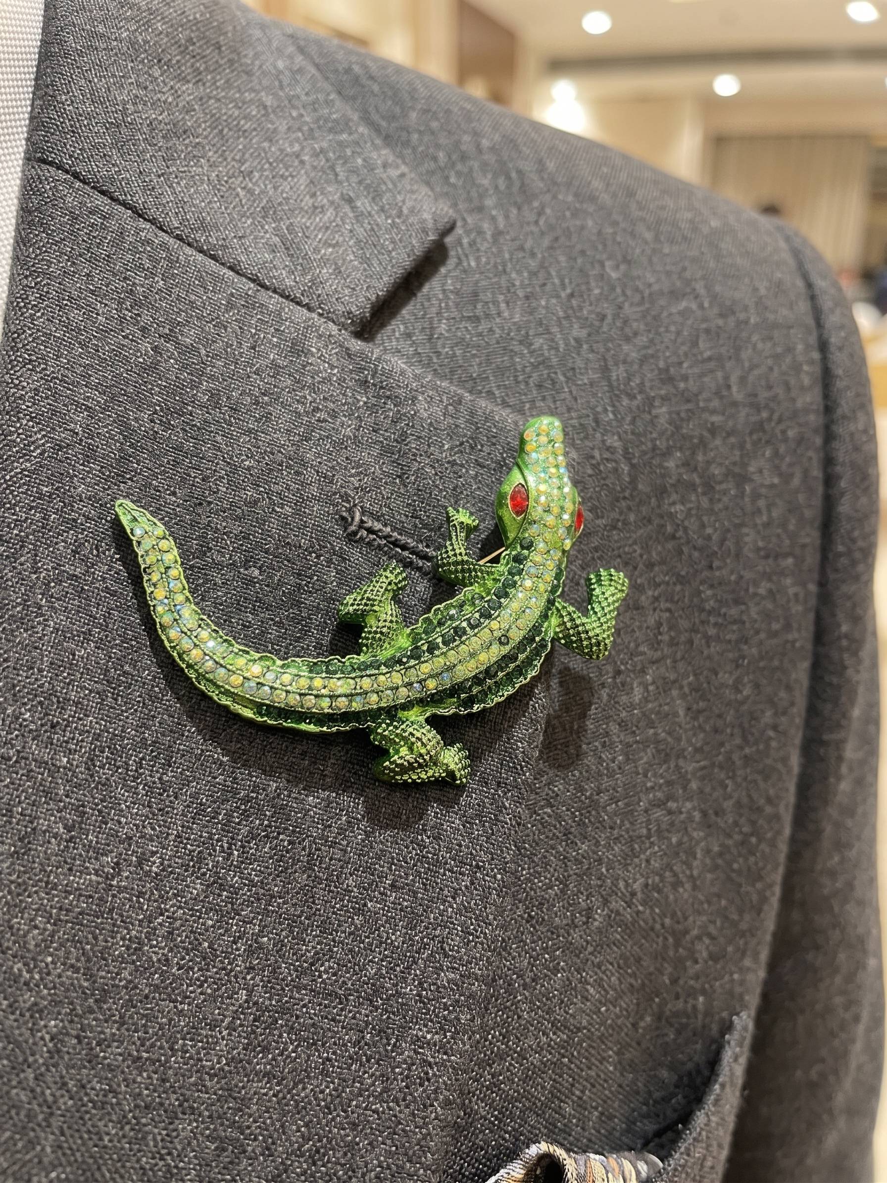 Green lizard brooch on a gray suit jacket