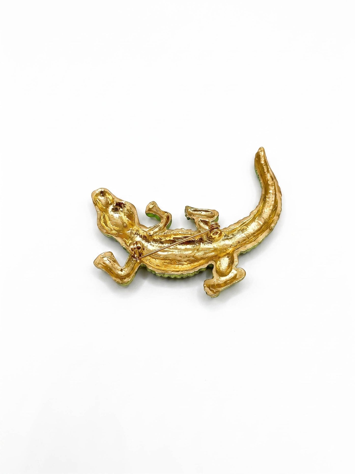 Gold lizard-shaped pendant on a white background