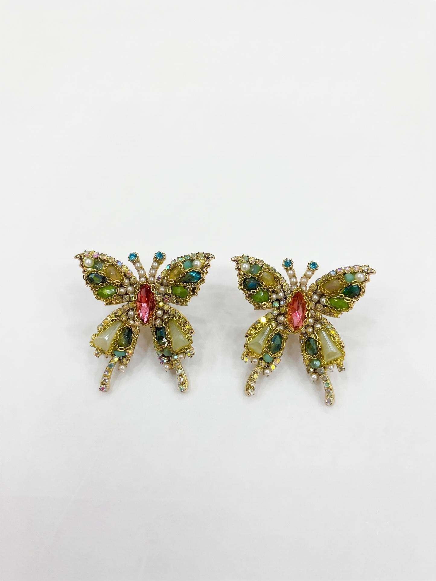 Butterfly-shaped earrings with gemstones on a white background