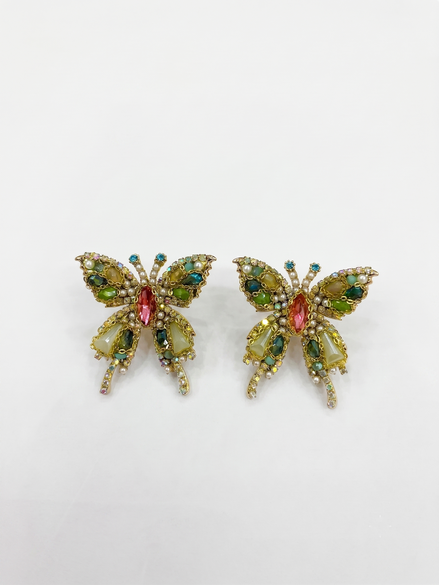 Butterfly-shaped earrings with gemstones on a white background