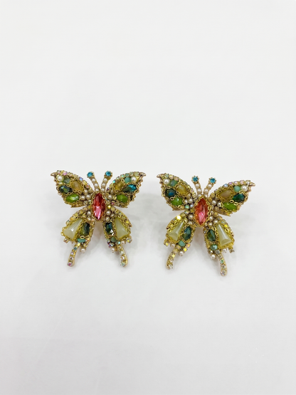Butterfly-shaped earrings with gemstones on a white background