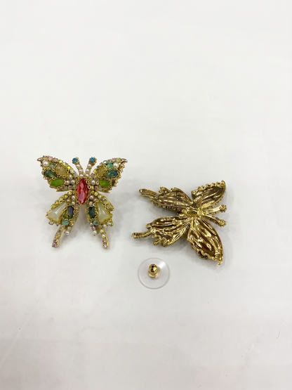 Butterfly-shaped earrings with gemstones on a white background