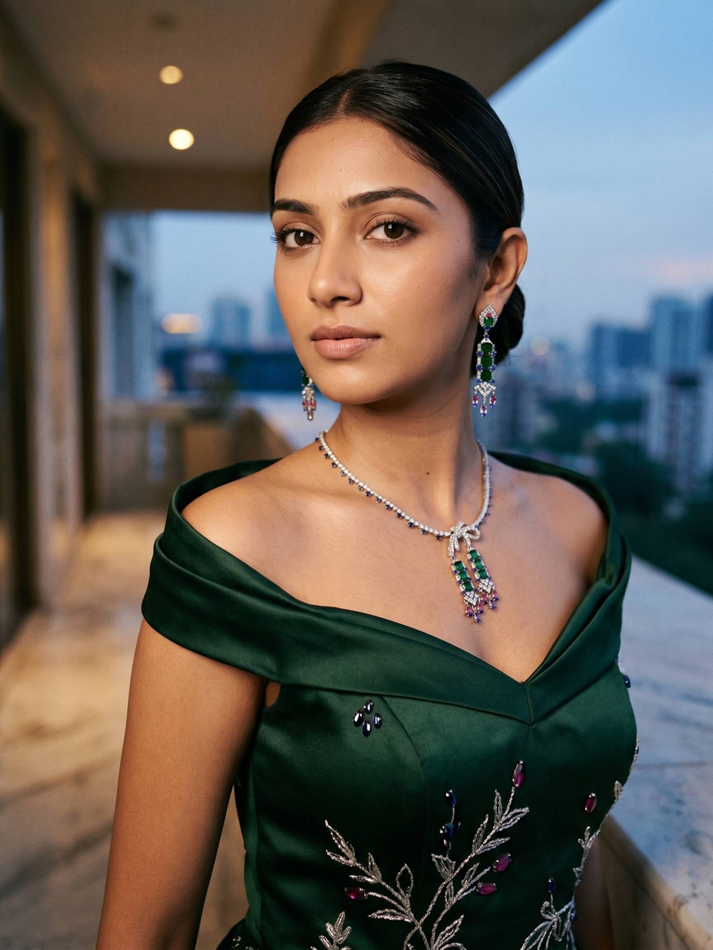 Woman wearing a green saree with jewelry in an outdoor setting