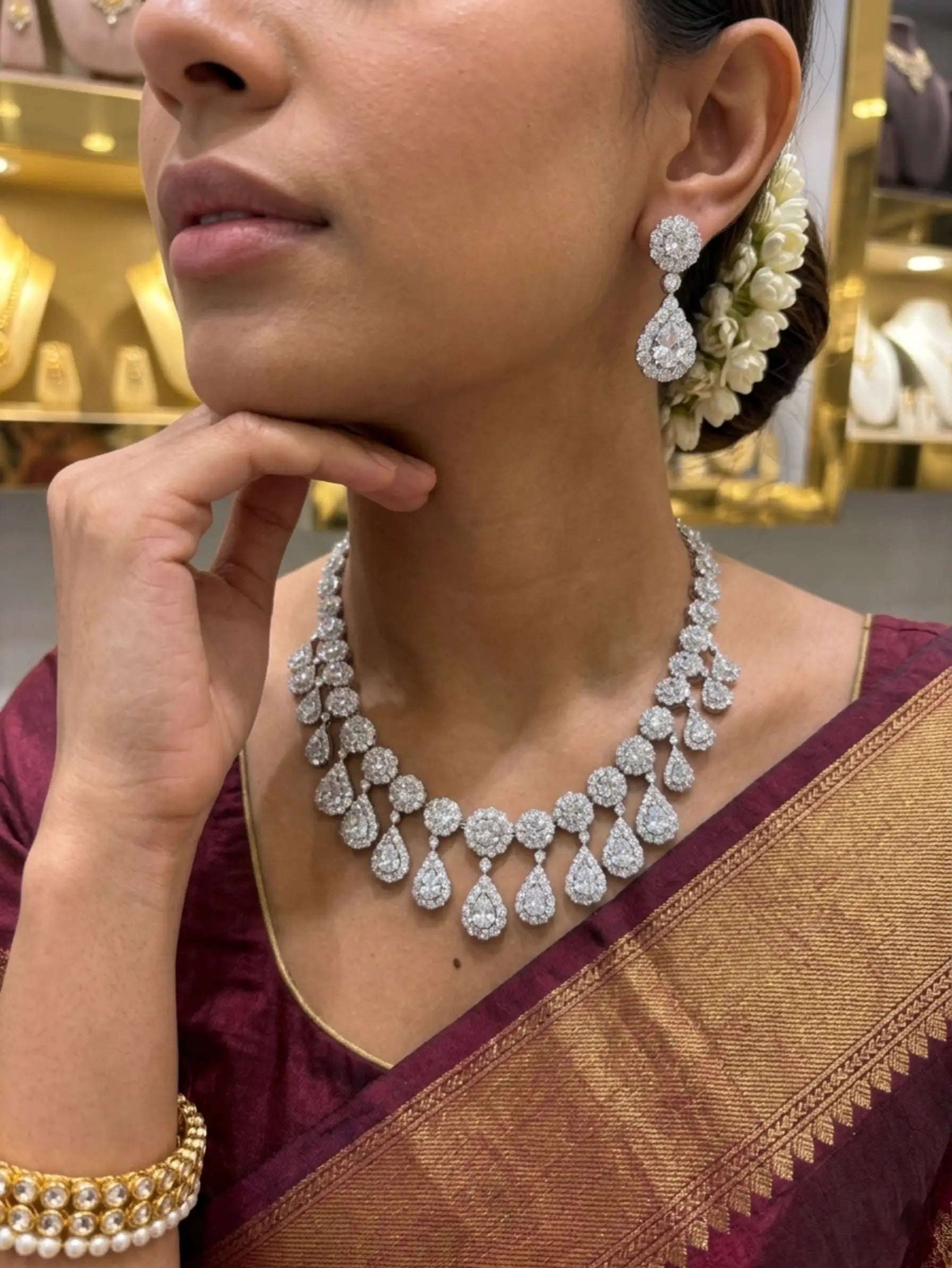 Woman wearing a diamond necklace and earrings in an elegant setting.