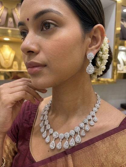 Woman wearing a diamond necklace and earrings in a jewelry store setting