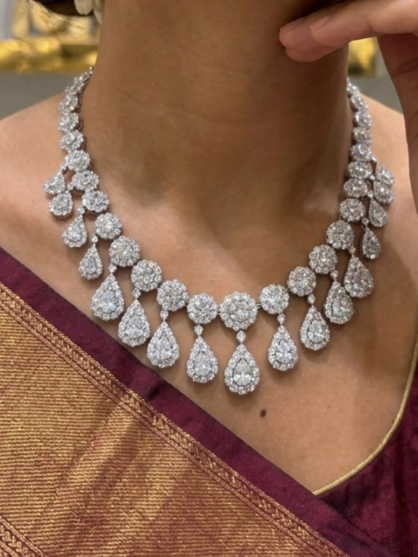 Diamond necklace worn by a person with a gold and red garment