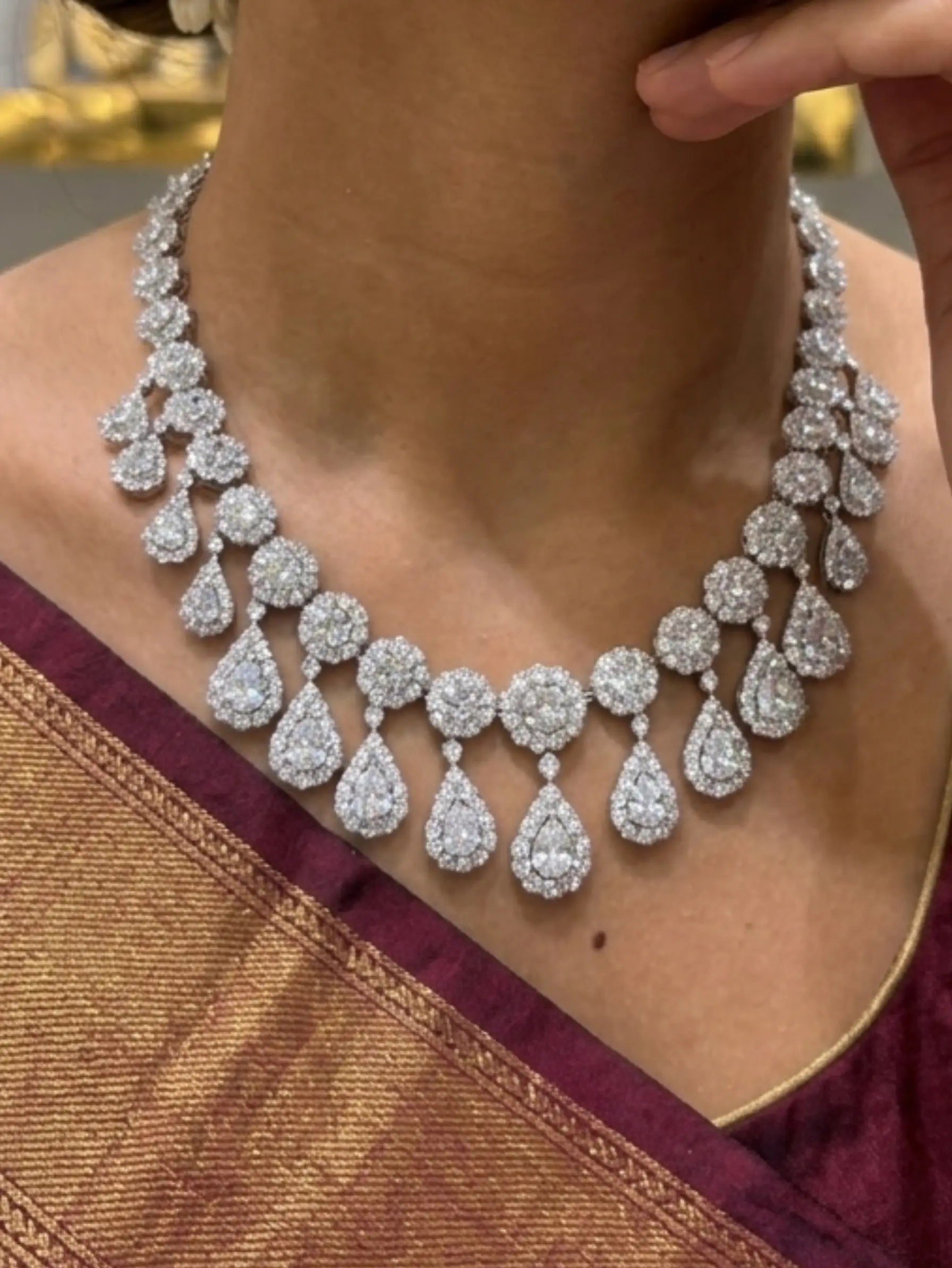 Diamond necklace worn by a person with a gold and red garment