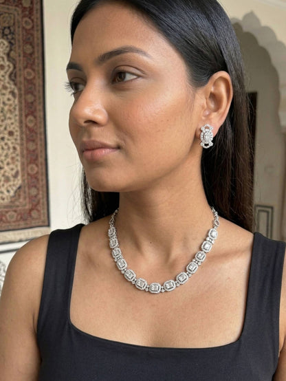 Woman wearing a diamond necklace and earrings indoors