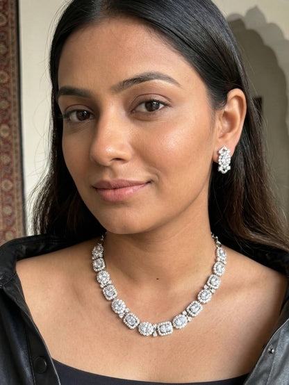 Woman wearing a diamond necklace and earrings indoors