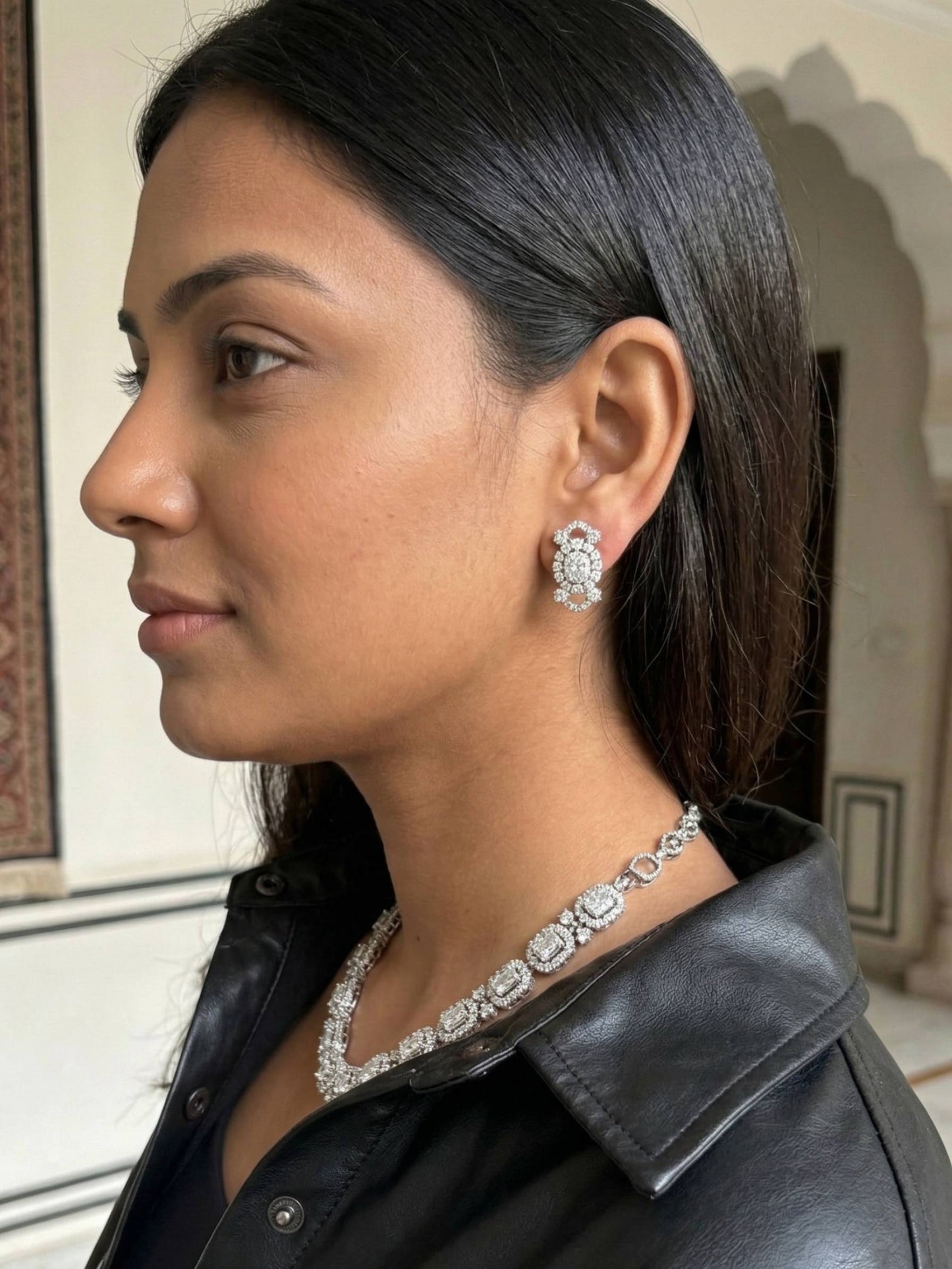 Woman wearing a diamond necklace and earrings indoors