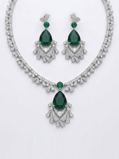 Jewelry set with emerald green gemstones and silver accents on a white background