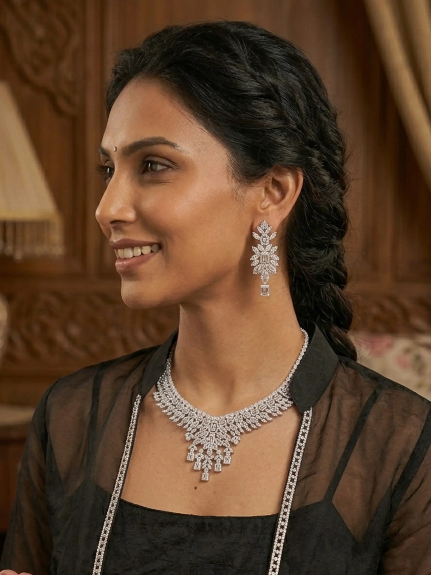 Woman wearing a diamond necklace and earrings indoors