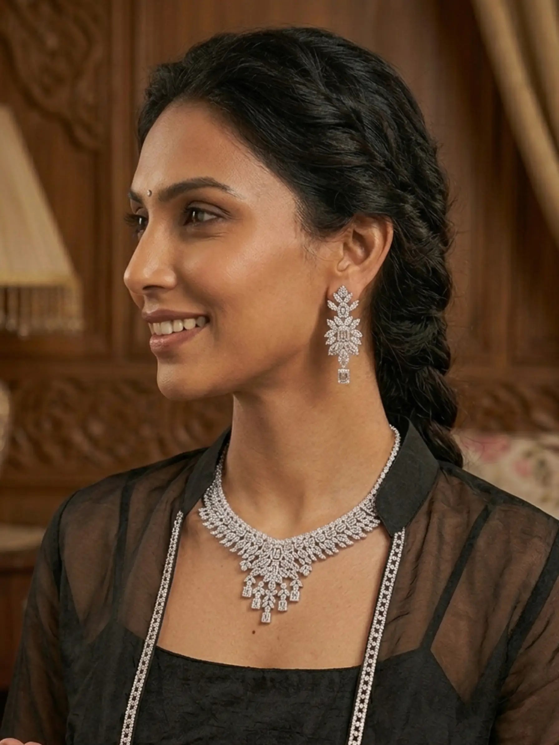 Woman wearing a diamond necklace and earrings indoors