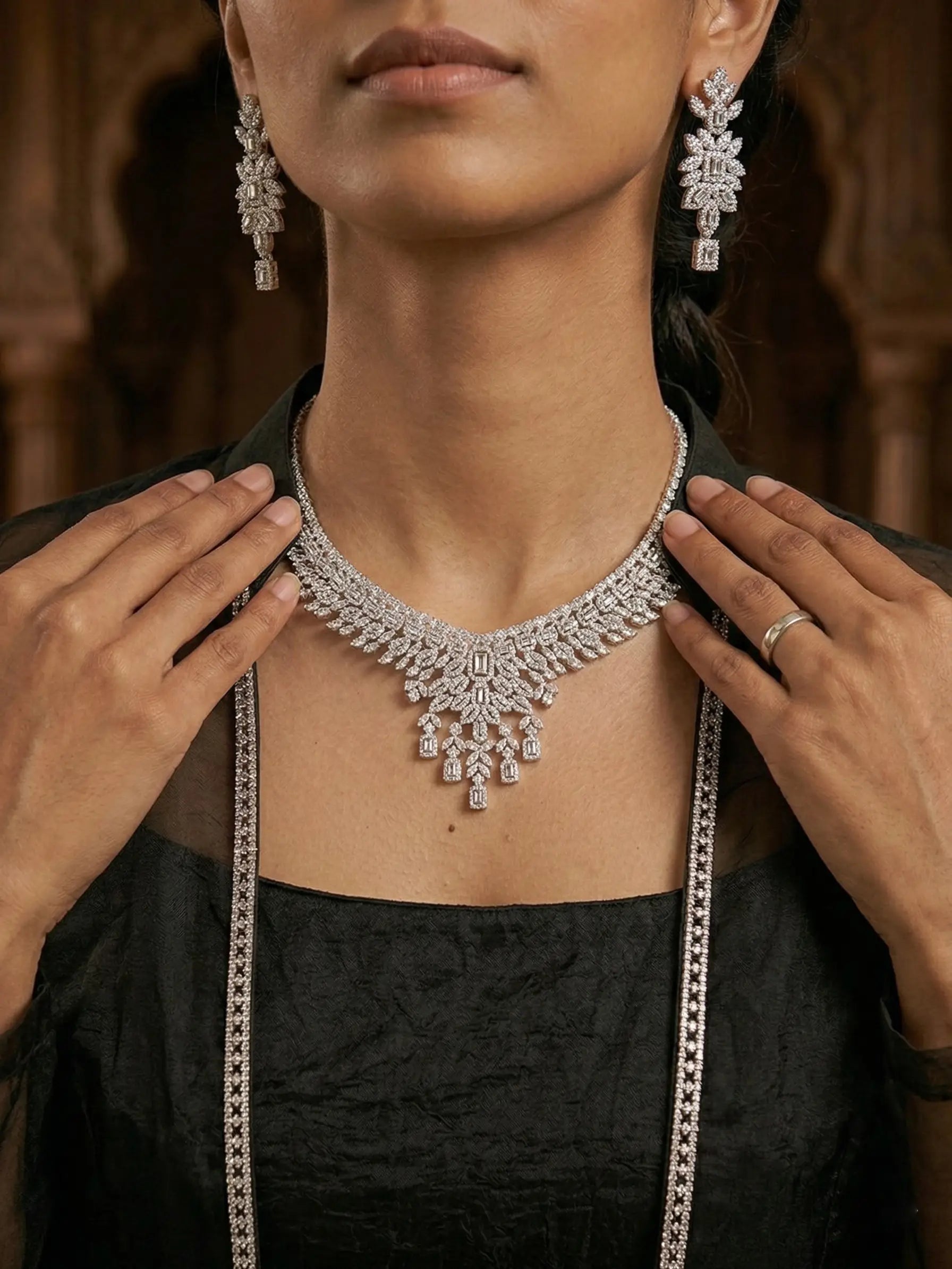 Woman wearing a silver necklace and earrings with a blurred background