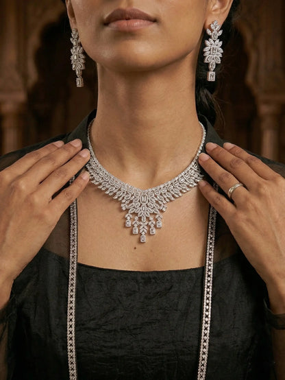 Woman wearing a silver necklace and earrings with a blurred background