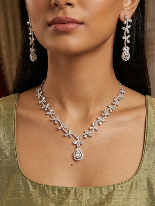 Woman wearing a diamond necklace and earrings with a green top.