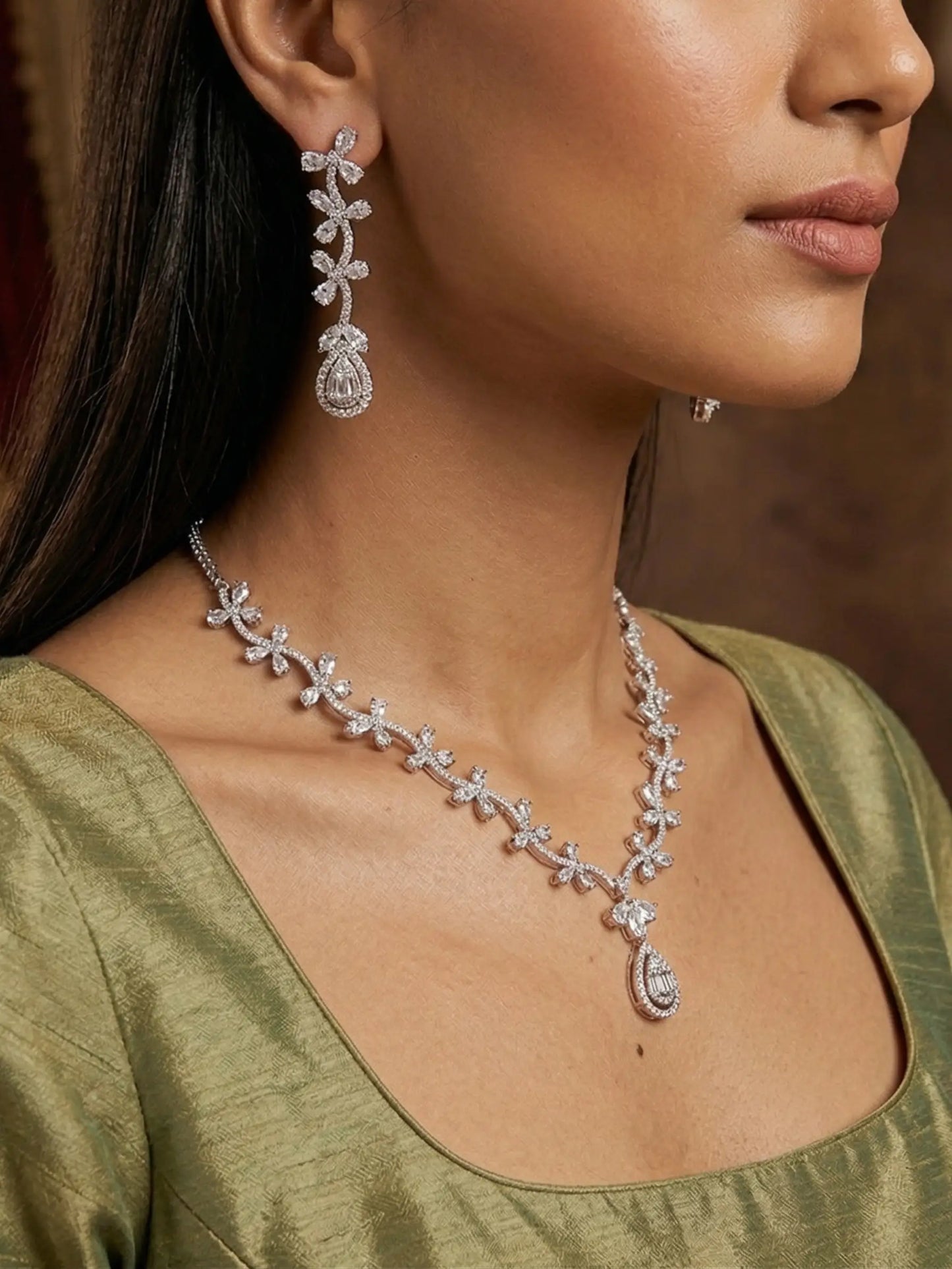 Woman wearing a diamond necklace and earrings with a blurred background