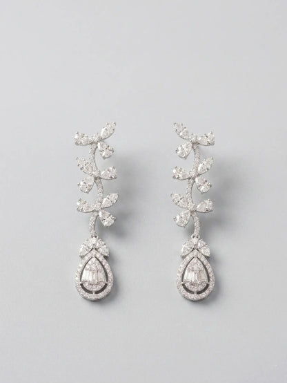 Pair of silver teardrop earrings with clear gemstones on a light gray background