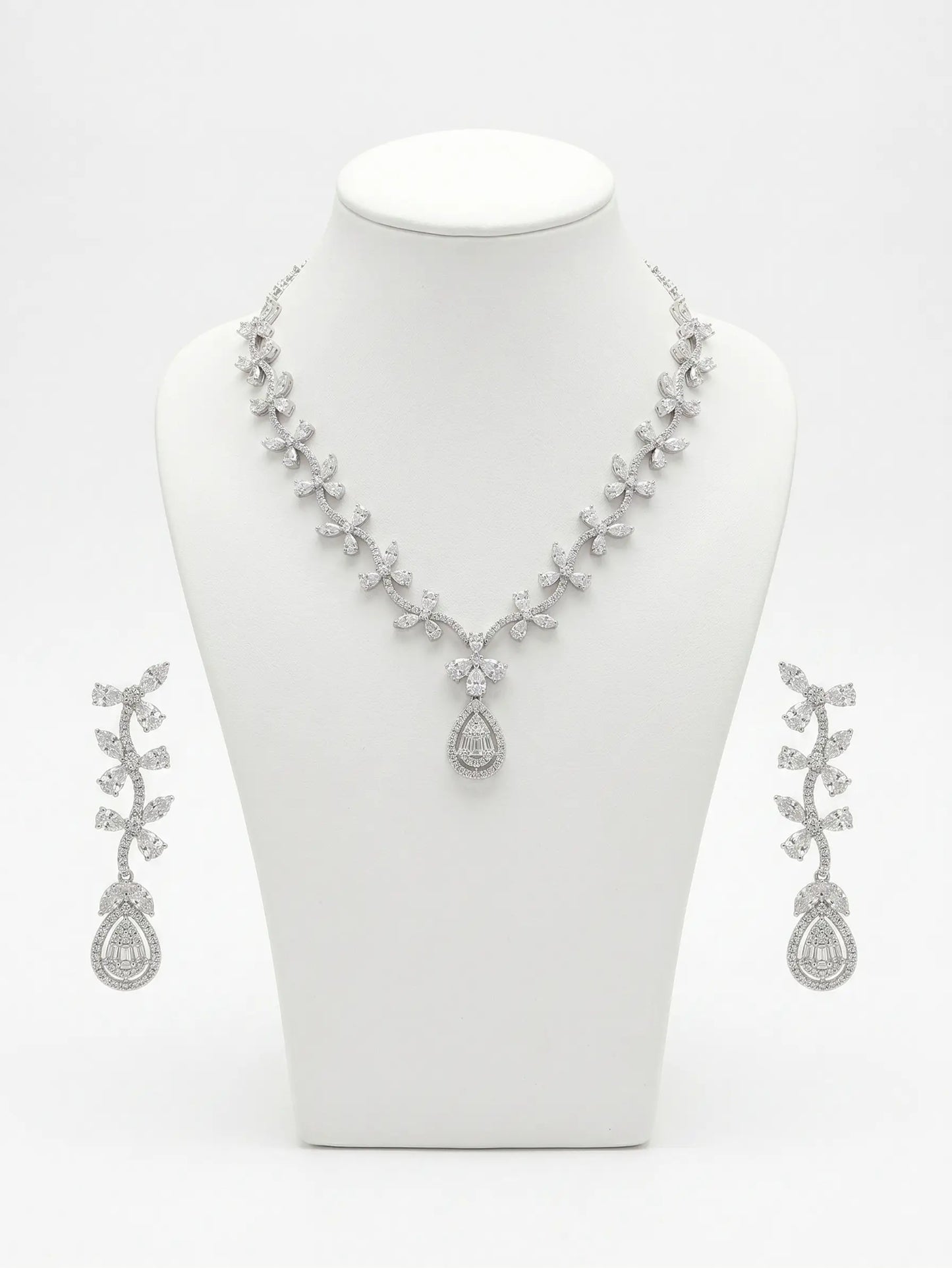 Silver necklace and earrings set on a white mannequin bust.