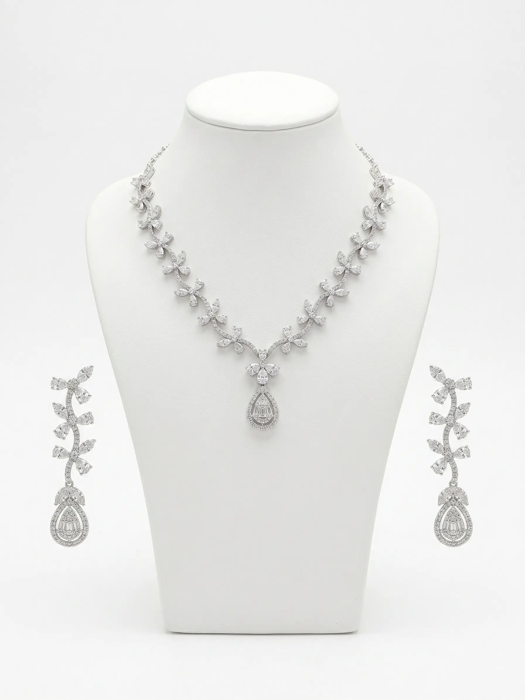 Silver necklace and earrings set on a white mannequin bust.