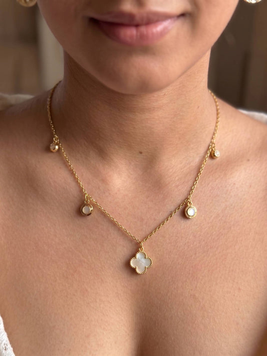 Gold necklace with a central pendant worn by a person