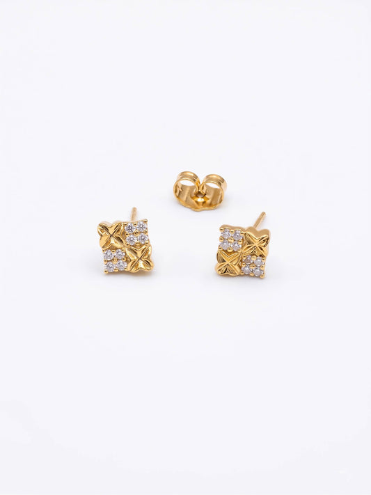 Gold earrings with diamond-like stones on a white background