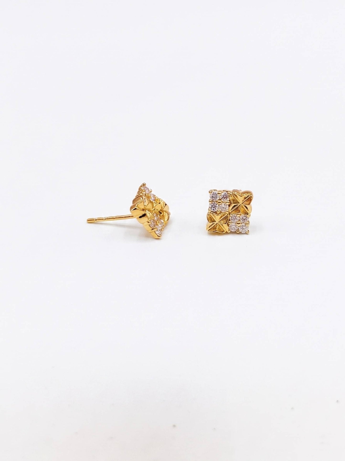 Gold earrings with intricate designs on a white background