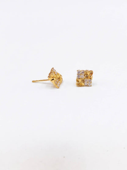 Gold earrings with intricate designs on a white background
