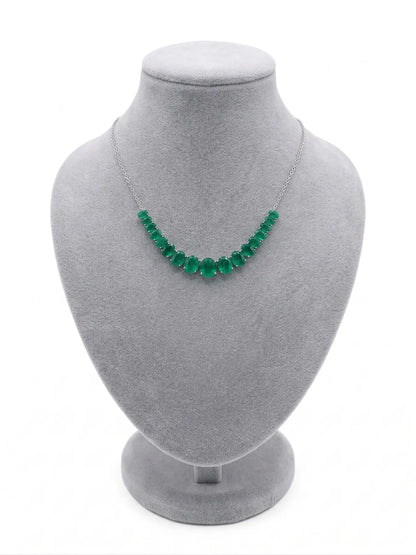 Green beaded necklace on a gray mannequin bust against a white background