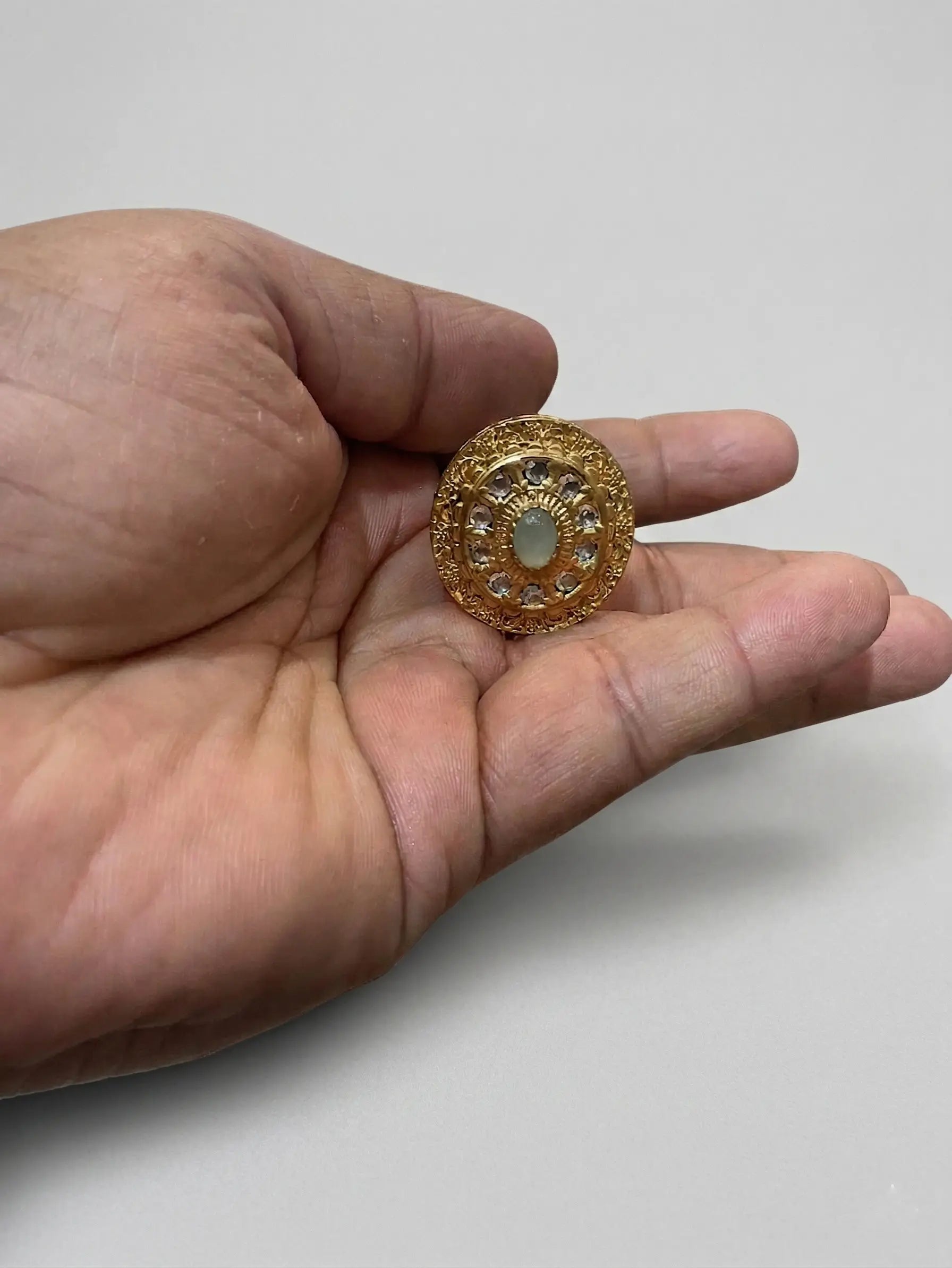 Close-up of a Swarovski-style stone ring for women with high-clarity CZ stones and intricate gold-plated circular patterns.