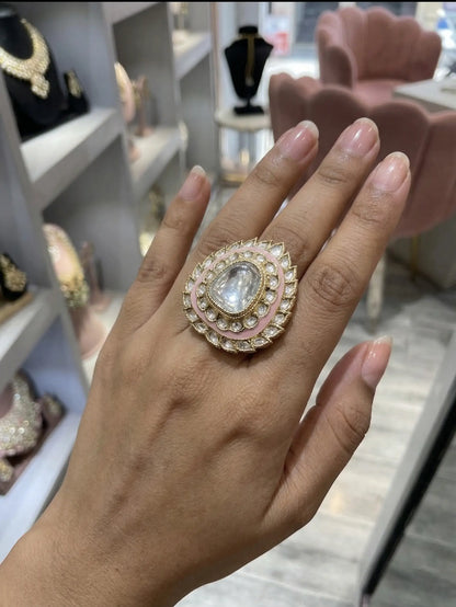 Hand wearing a decorative ring with a gemstone in a store setting