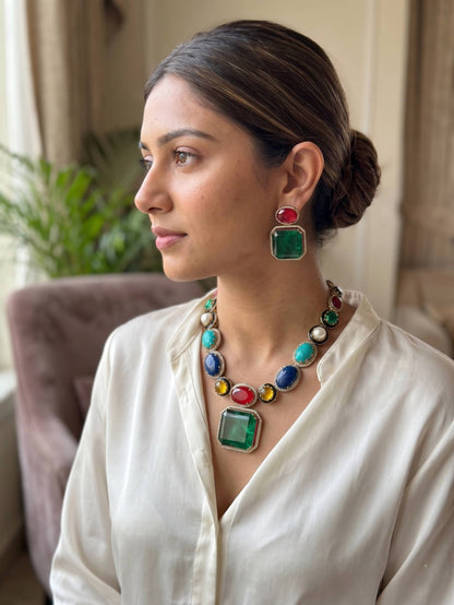 Woman wearing a colorful necklace and earrings indoors