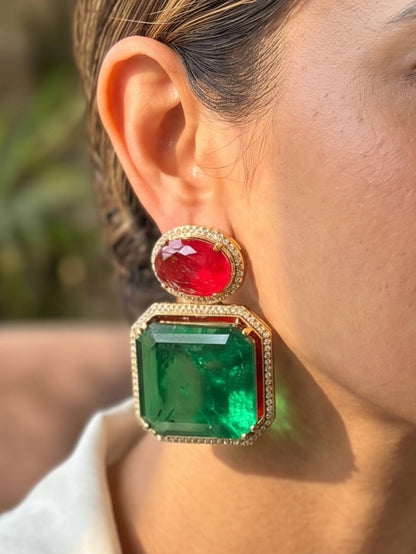 Close-up of a person wearing a red and green gemstone earring.