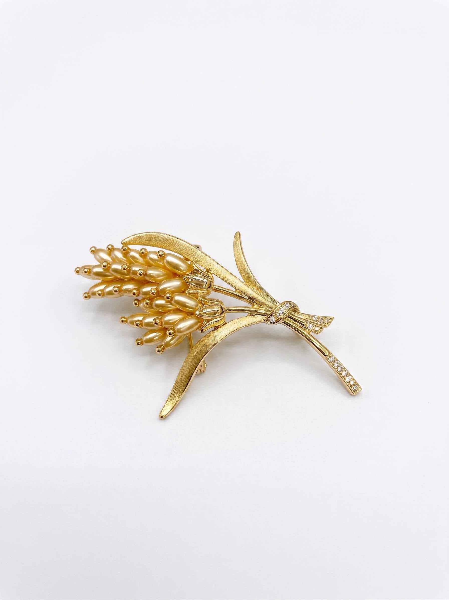 Gold brooch with floral design on a white background