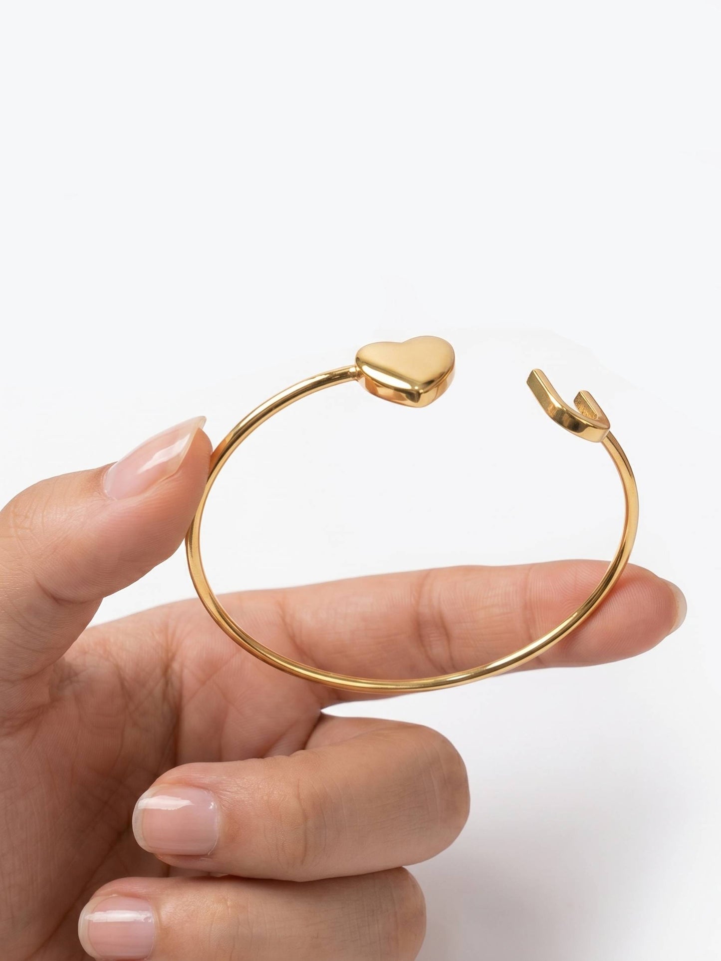 Gold bracelet with initial U and heart charm.