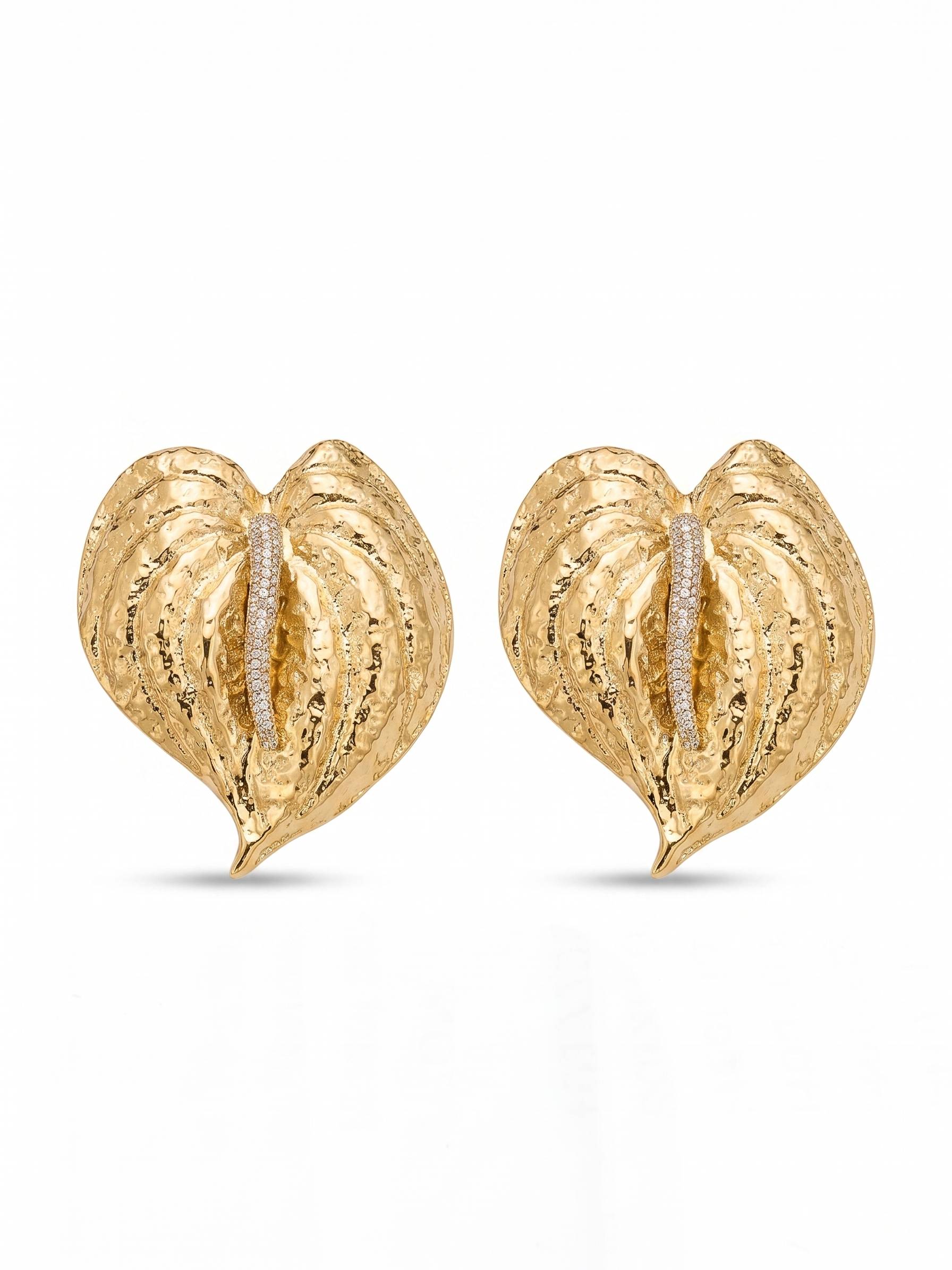 Gold heart-shaped earrings with embedded diamonds on a white background