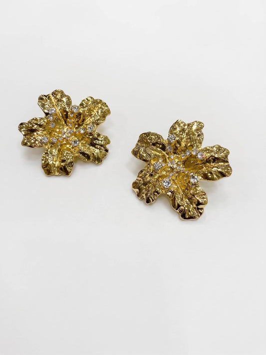 A stunning earrings design featuring a 3D textured gold flower with a radiant crystal-encrusted center.