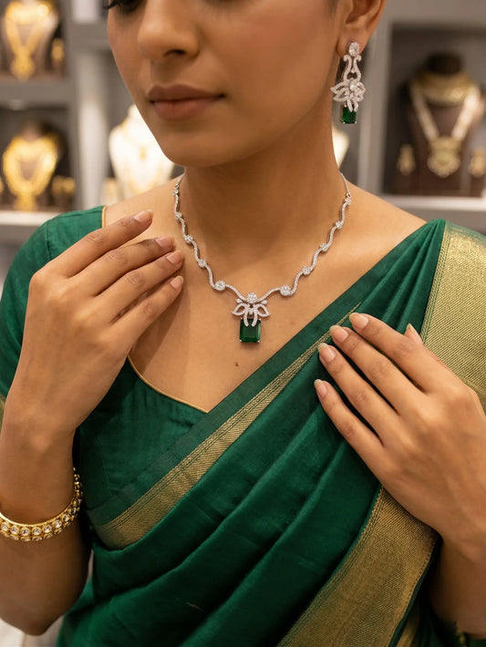 Woman wearing a green saree with jewelry, including a necklace and earrings, in a store setting.