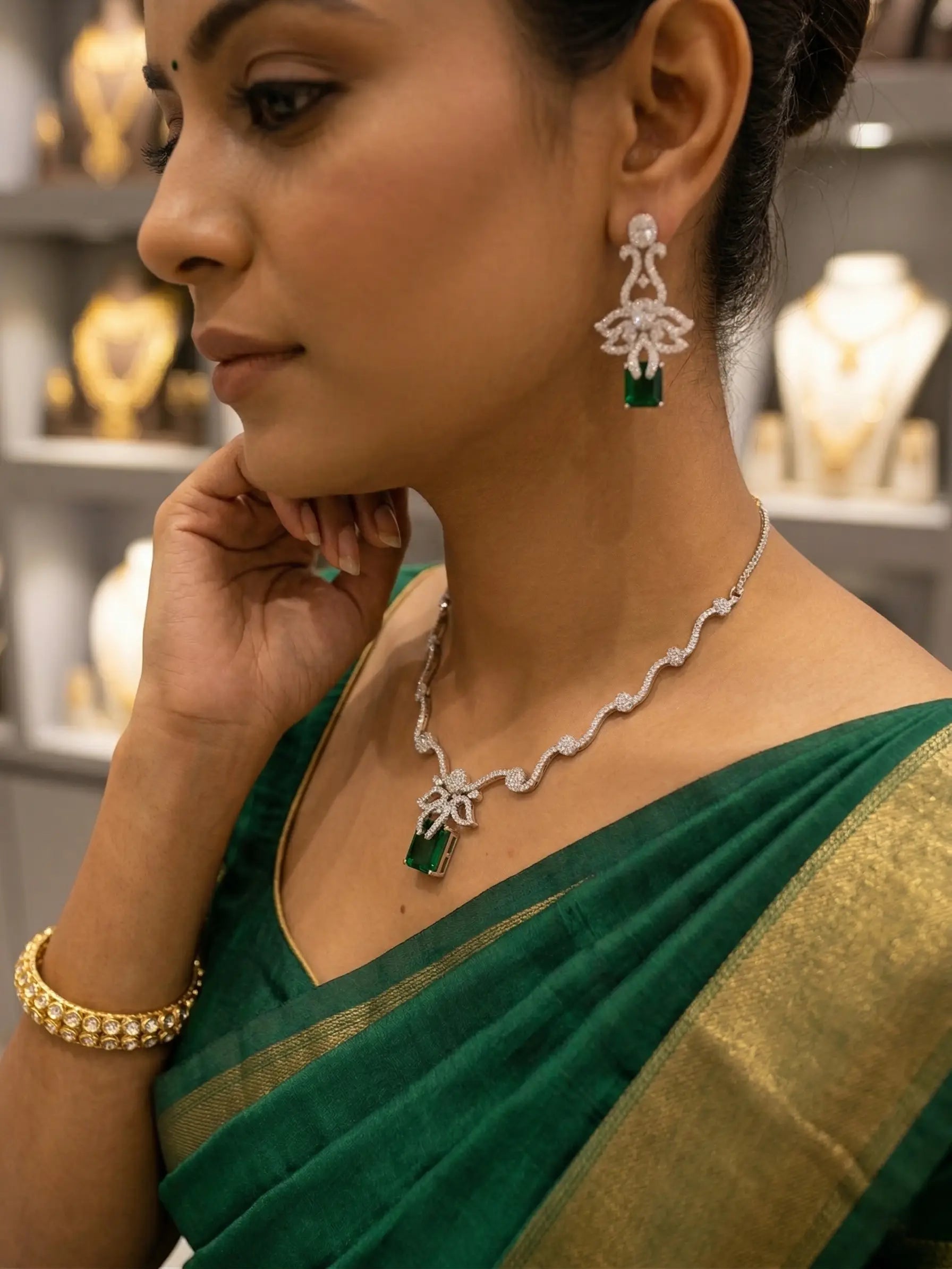 Woman wearing green saree with jewelry including necklace and earrings.