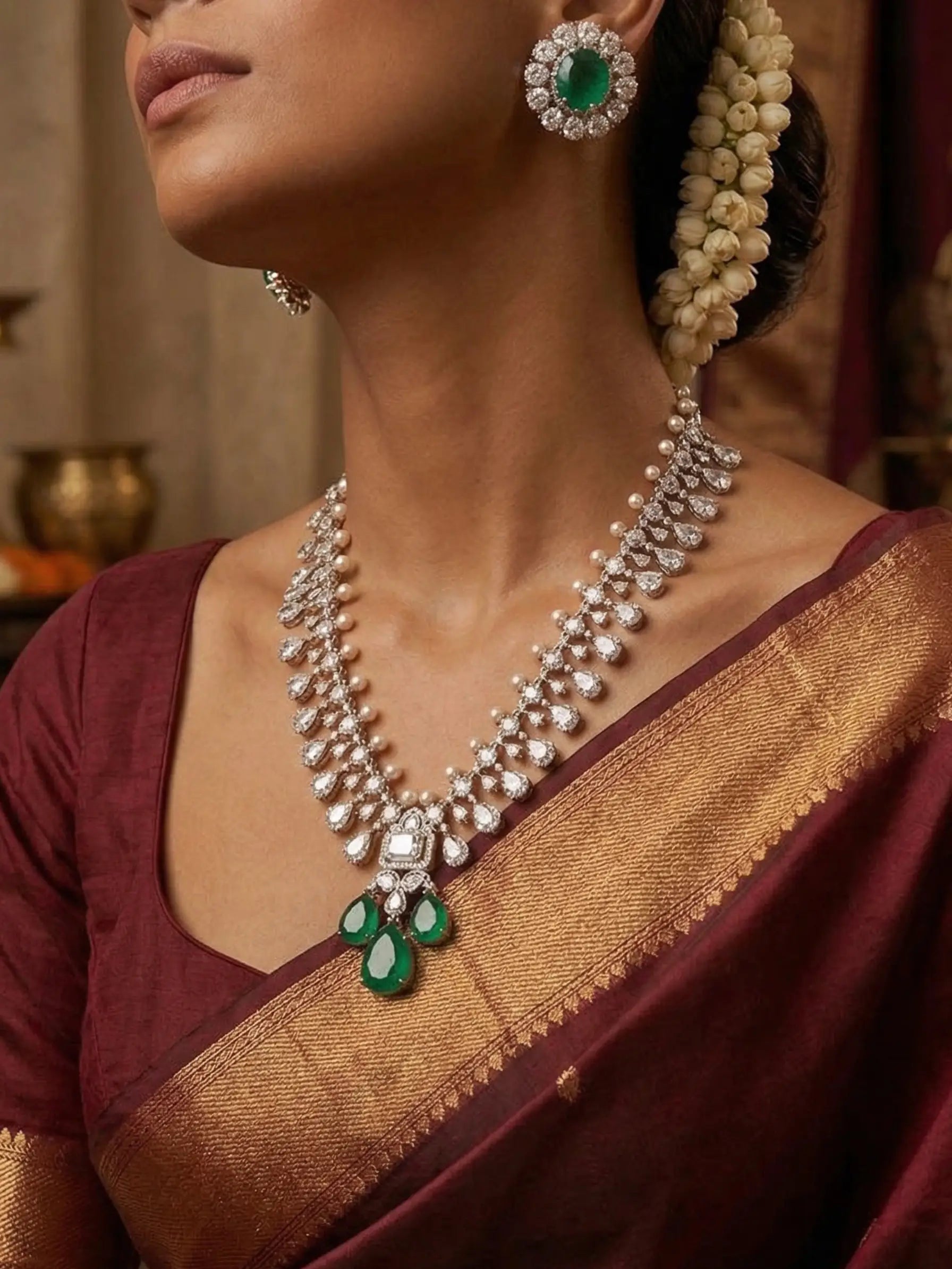 Woman wearing a traditional maroon saree with gold border, diamond necklace, and earrings.