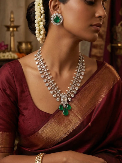 Woman wearing a traditional maroon saree with gold jewelry, including earrings and a necklace.